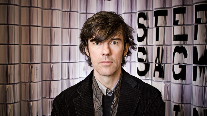 Stefan Sagmeister vor einem Vorhang stehend