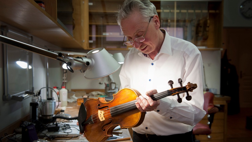 Marcel Richters mit Geige in der Werkstatt.