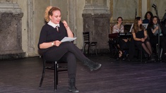 Kreatives Schreiben © Roman Picha Lesende Dame auf einem Stuhl vor Publikum.