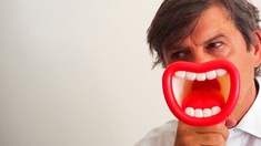 (c) netzzeit Mann vor weißem Hintergrund mit Plastiklippen vorm Gesicht