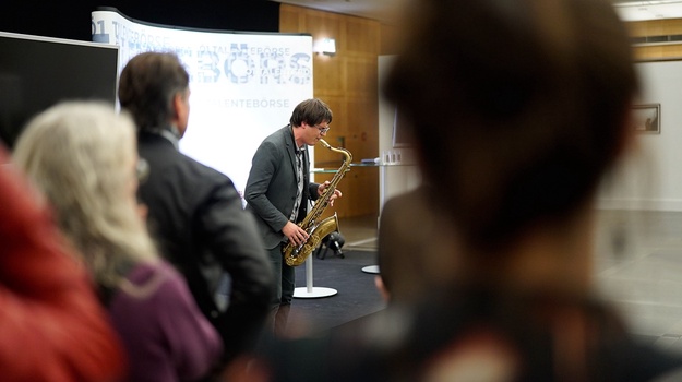 Ein Saxofonist inmitten seines Publikums